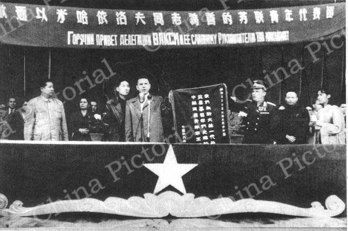 
中国新民主主义青年团书记冯文彬同志代表中国新民主主义青年团向苏联列宁共产主义青年团献旗。图中前排自左至右为：廖承志，米哈依洛夫，关日杜布，冯文彬。
