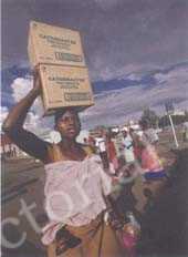 
顶物是非洲妇女普遍使用的方式，镜头中的这个妇女头顶两箱食用油，背后还背着自己的孩子。
莫桑比克
